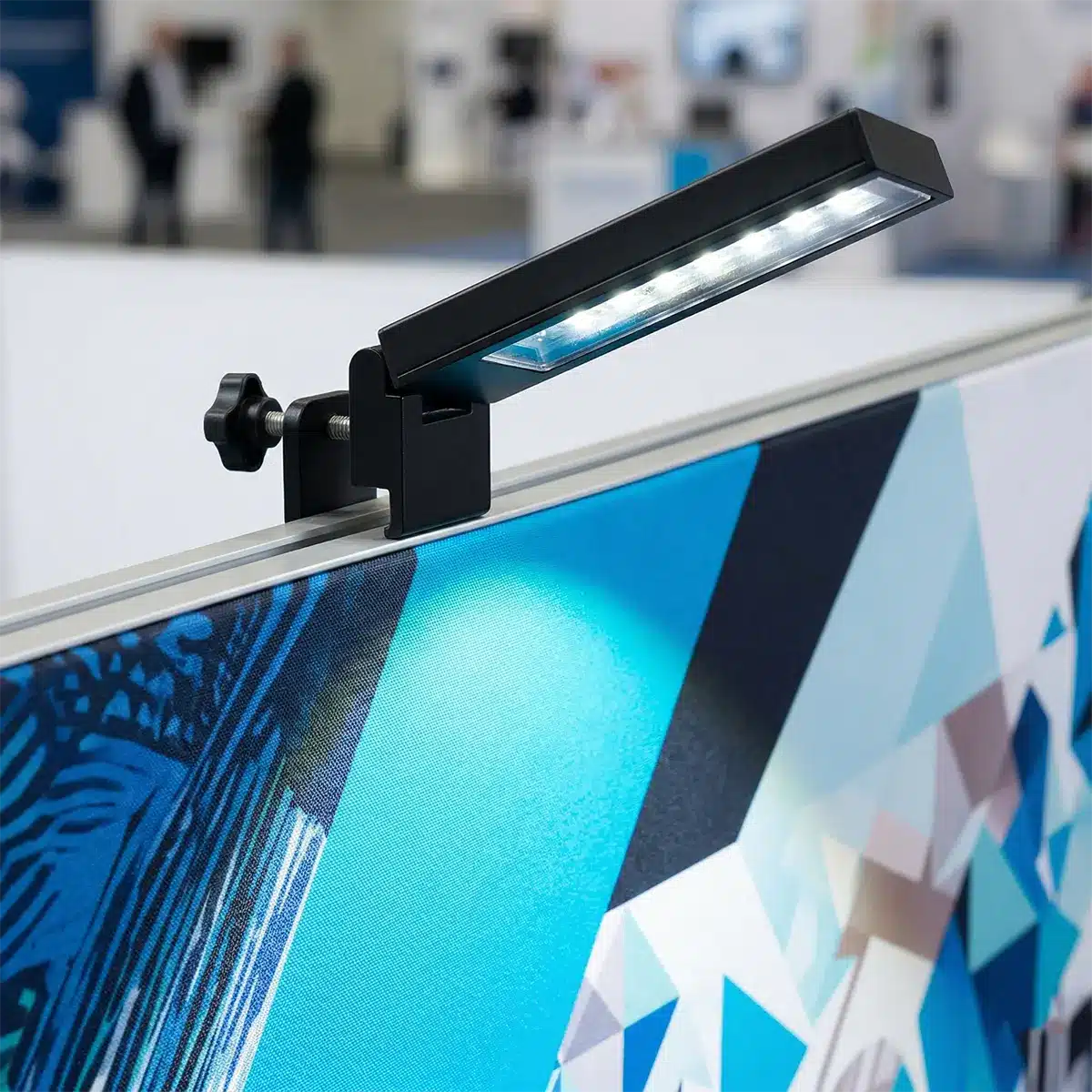 LED Display Lighting Kit for Event Backdrops LED clamp light attached to the top edge of a trade show pop up display.