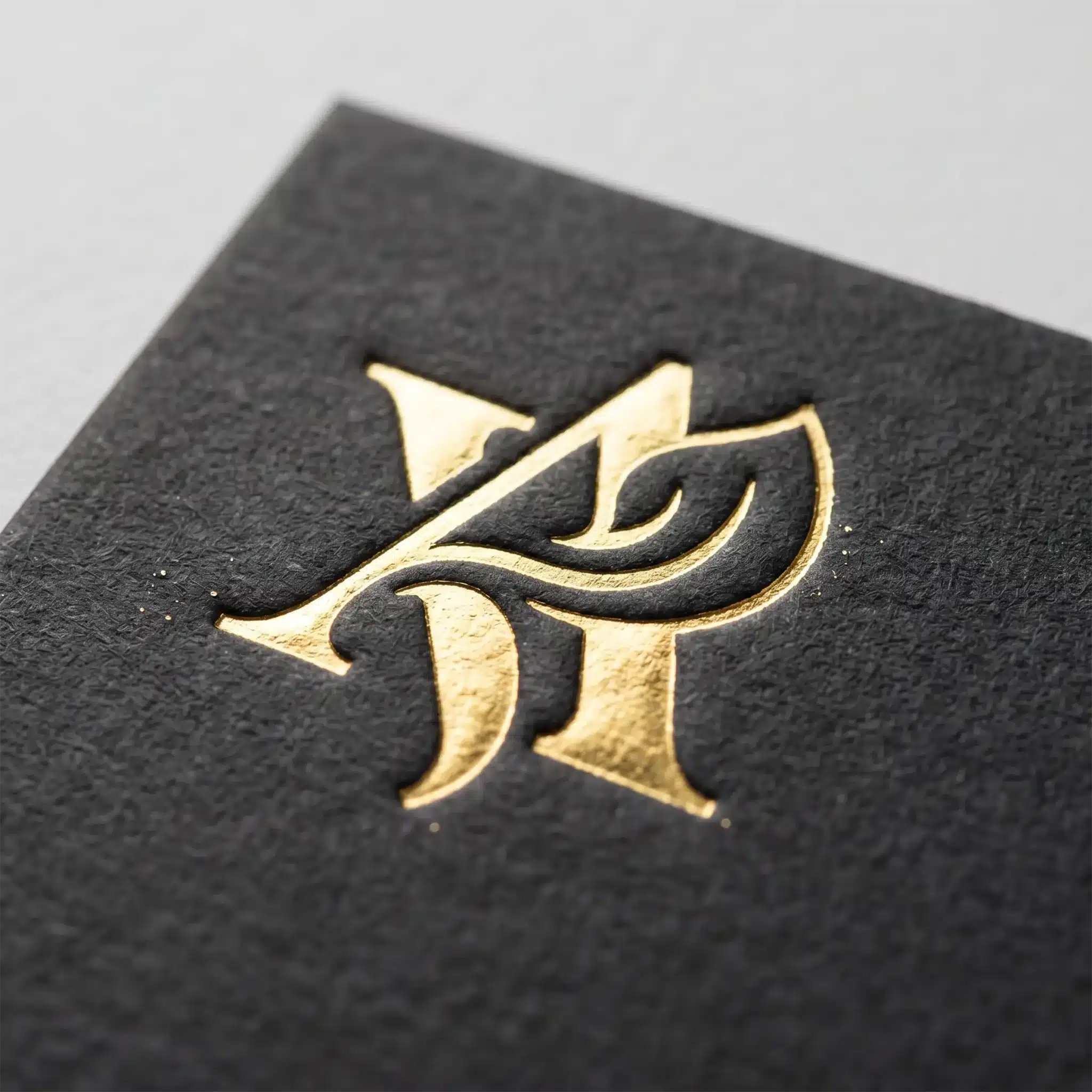 Finishing Services 6 Close-up of Manhattan gold foil stamping on a black textured surface with crisp raised lettering in reflective metallic finish.