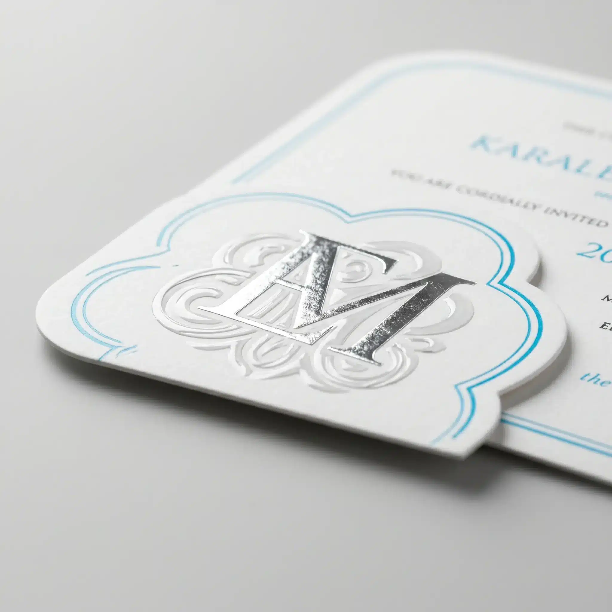 Finishing Services 8 White printed material with an embossed raised design and blue linework, showing crisp edges and layered finish effects.