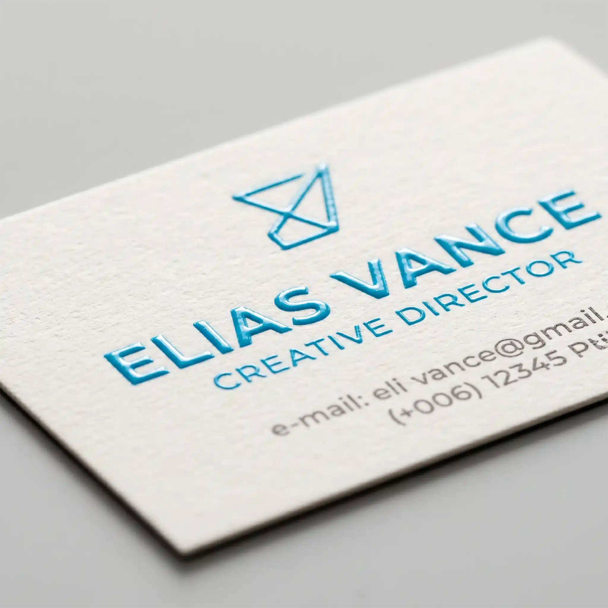 Finishing Services 9 Close-up of raised ink thermography printing with bold blue raised lettering on light paper, showing crisp textured edges and depth.