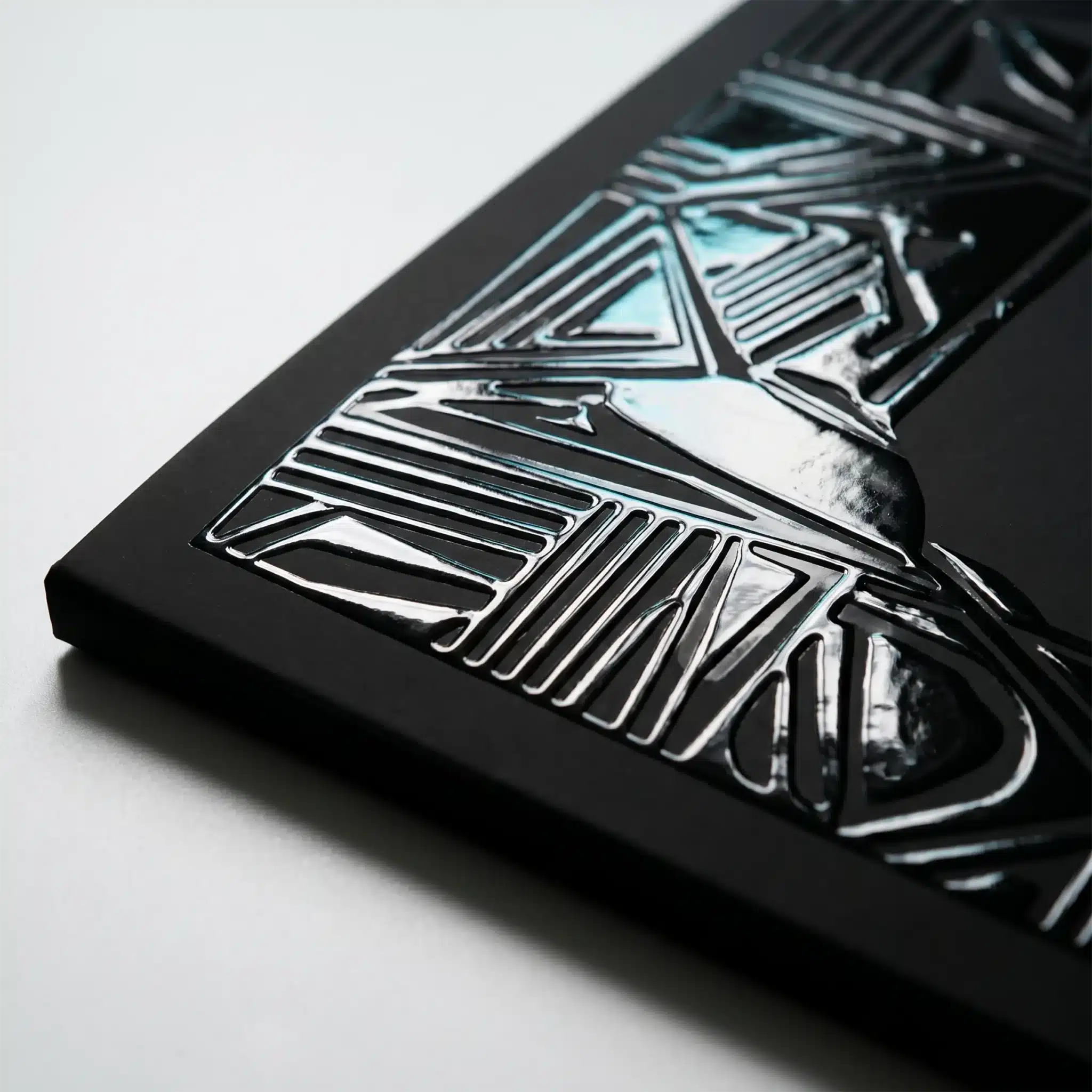 Finishing Services 11 Raised metallic UV coating creates a glossy 3D embossed pattern on a dark printed surface with crisp highlights and high contrast details.