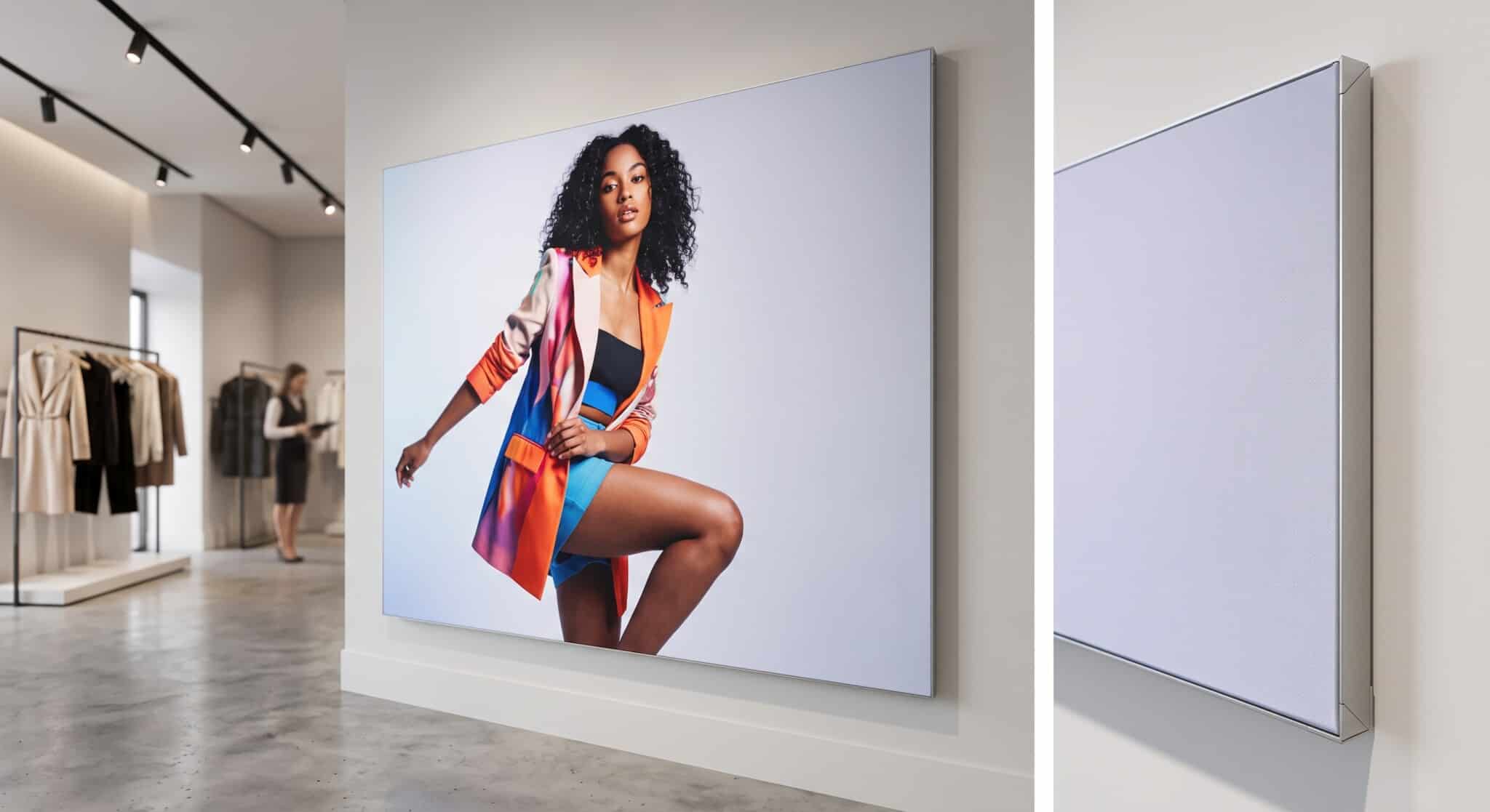 A large, borderless SEG tension fabric display in a modern clothing store, showing a fashion image of a model.